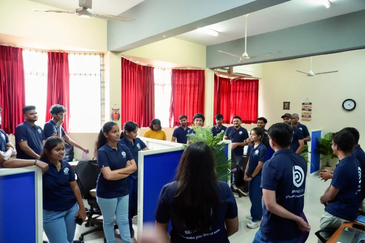 The Brand Elite team gathered in a circle for a morning huddle in the office